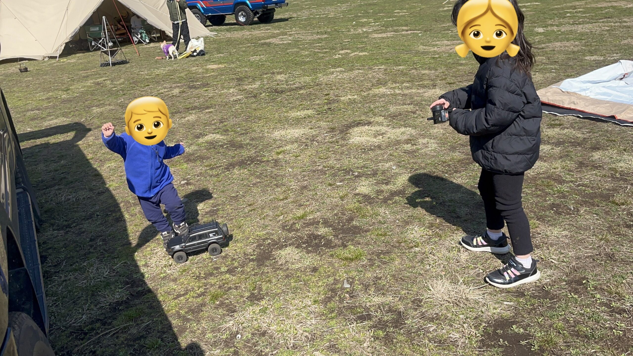 ふもとっぱらでラジコンを追いかけて遊ぶ子ども